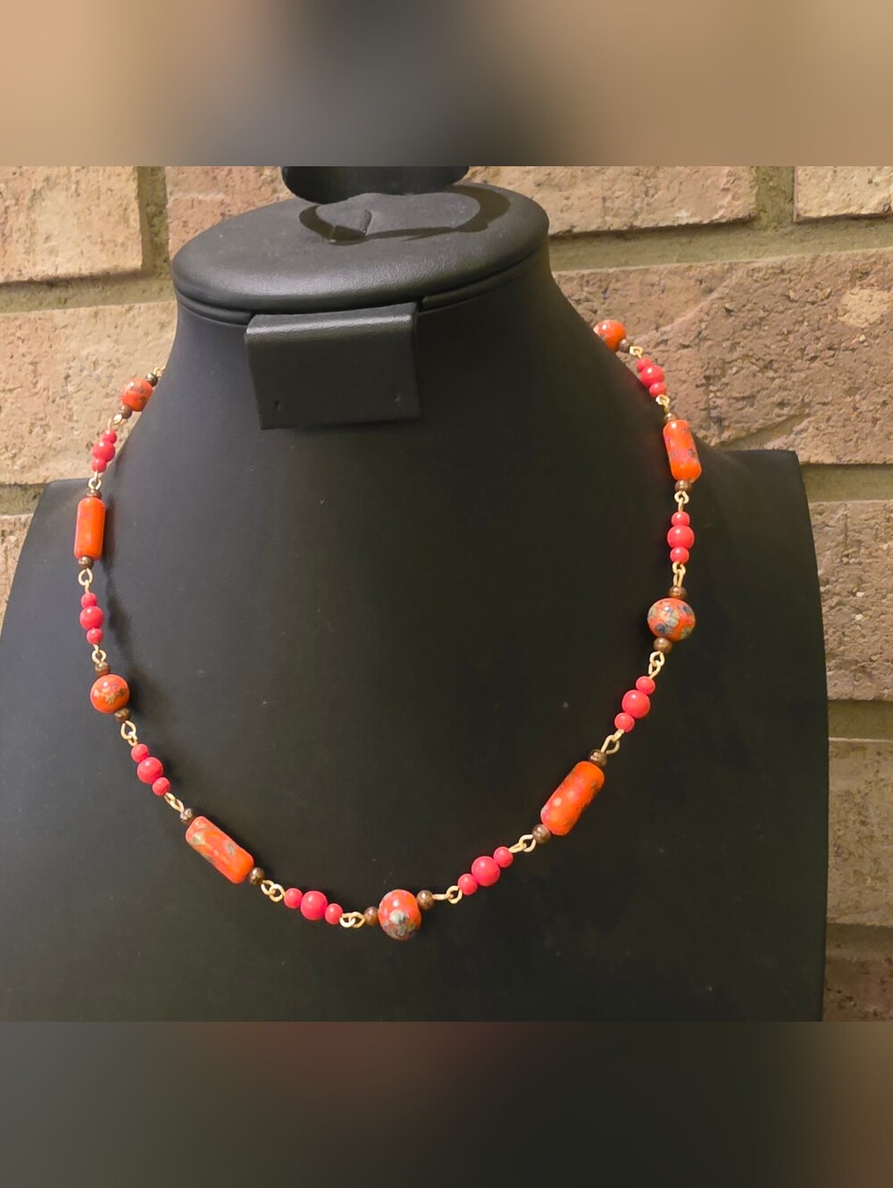 Vintage beaded necklace features bright orange cylindrical and round glass beads